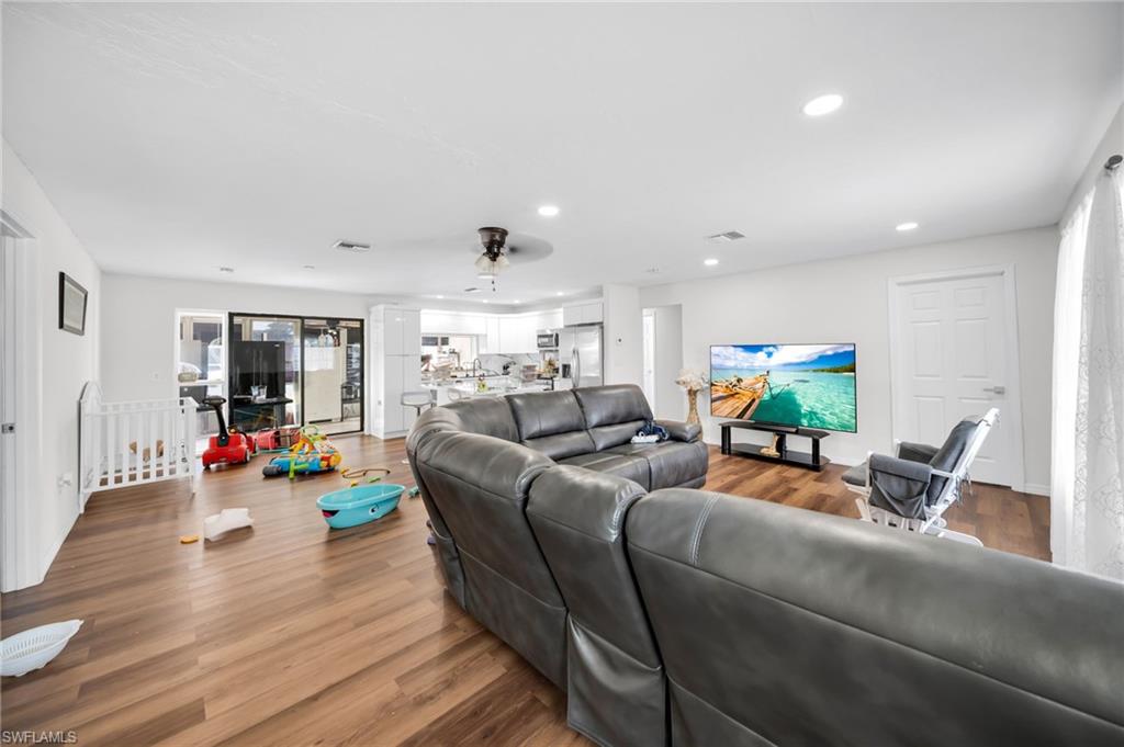 Living room with recessed lighting, wood finished floors, and a ceiling fan