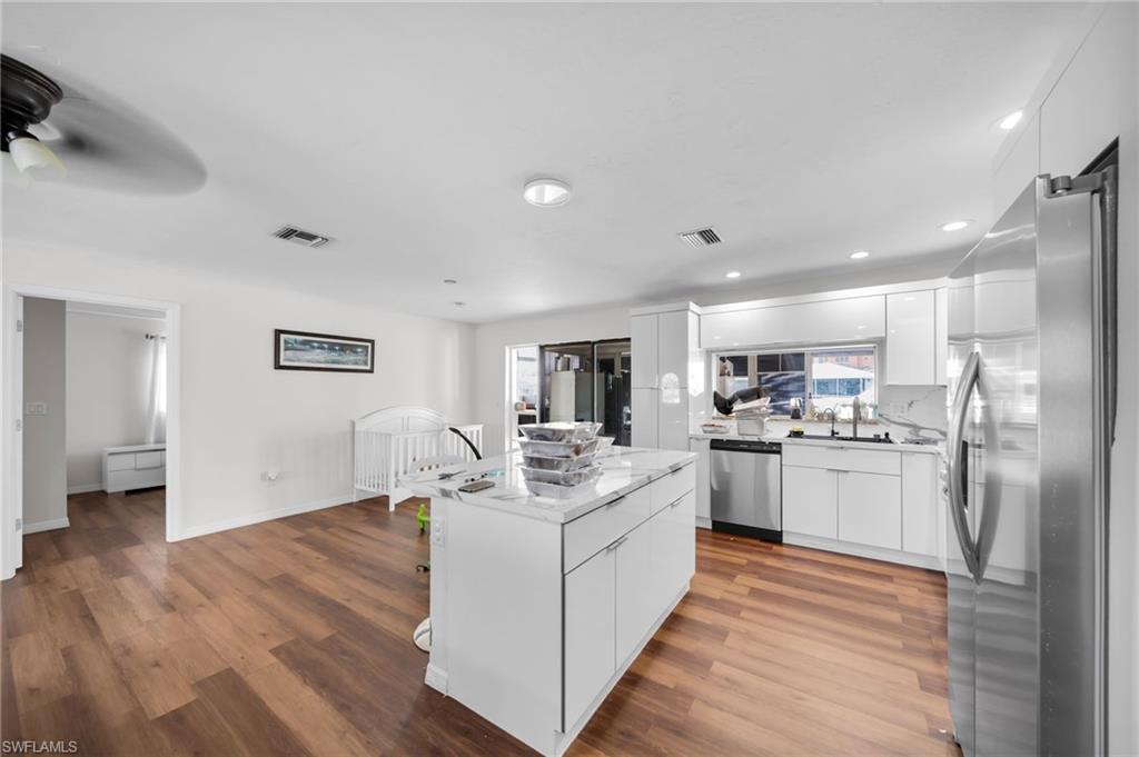 Kitchen featuring appliances with stainless steel finishes, modern cabinets, wood finished floors, and recessed lighting