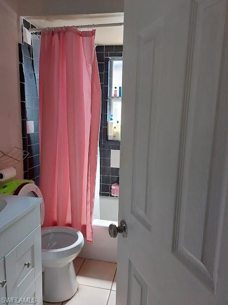 Bathroom featuring tile patterned floors, vanity, toilet, and shower / bathtub combination with curtain