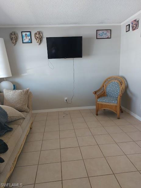 Sitting room featuring crown molding, a textured ceiling, light tile patterned floors, and baseboards