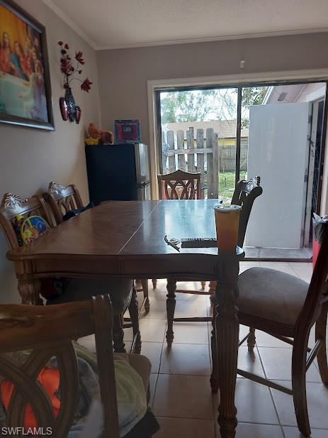 Dining space with ornamental molding and tile patterned floors