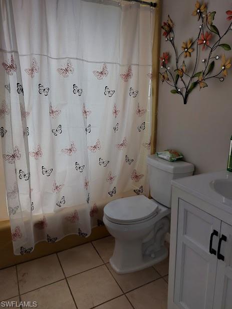 Full bathroom featuring tile patterned floors, toilet, vanity, and shower / tub combo