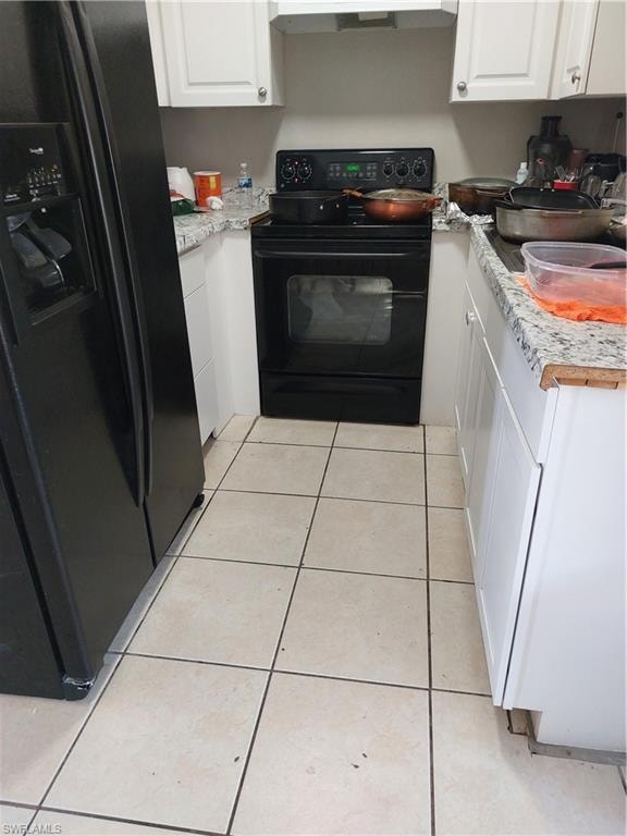 Kitchen with fridge, range, white cabinetry, and light countertops