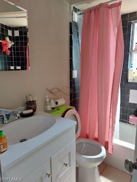 Bathroom featuring vanity, toilet, and shower / tub combo