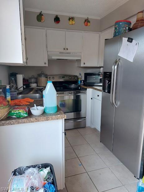 Kitchen with appliances with stainless steel finishes, under cabinet range hood, a sink, white cabinets, and ornamental molding