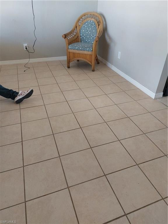 Sitting room featuring light tile patterned floors and baseboards