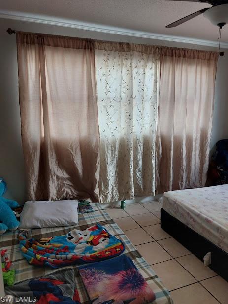 Bedroom with light tile patterned flooring and a ceiling fan