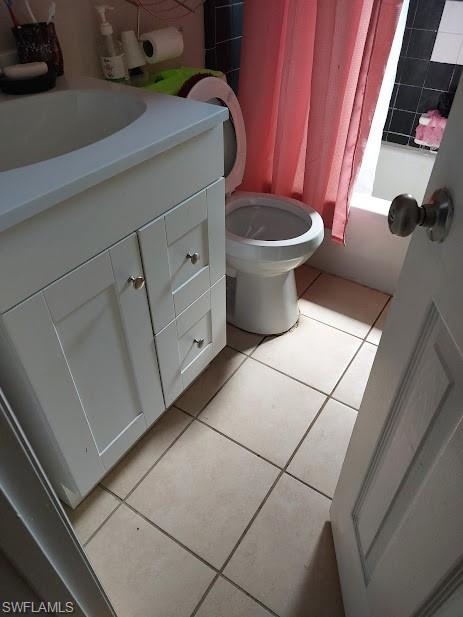 Bathroom featuring tile patterned floors, vanity, toilet, and shower / bath combo