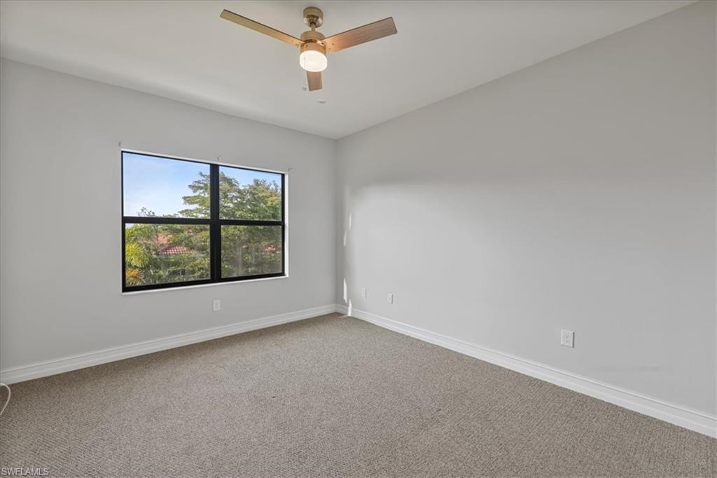 Spare room with carpet flooring, a ceiling fan, and baseboards