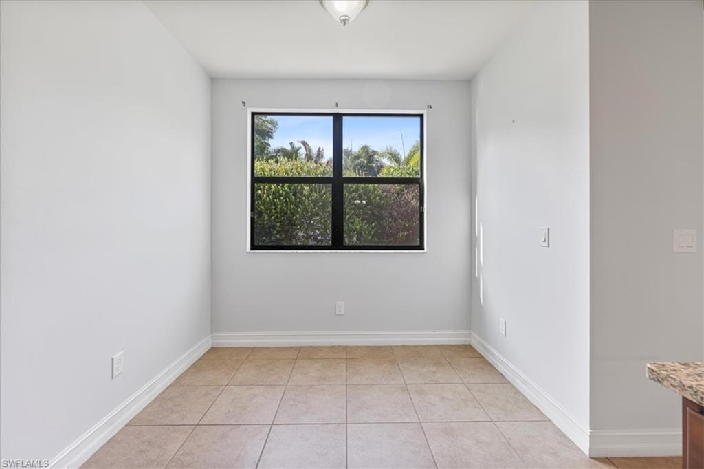 Empty room featuring light tile patterned flooring and baseboards