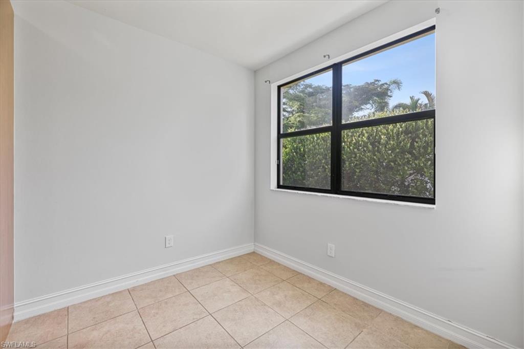 Empty room featuring baseboards and light tile patterned floors