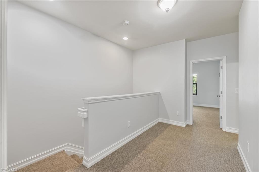 Hall featuring carpet, baseboards, an upstairs landing, and recessed lighting