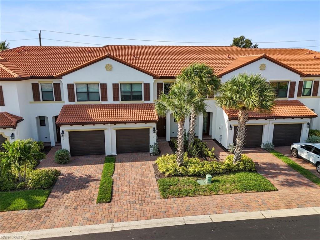 Mediterranean / spanish-style home featuring a tile roof, stucco siding, driveway, and an attached garage