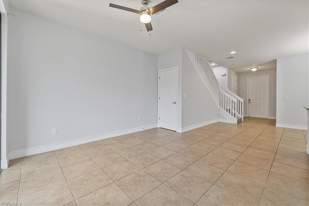 Unfurnished room featuring stairs, ceiling fan, light tile patterned flooring, baseboards, and recessed lighting