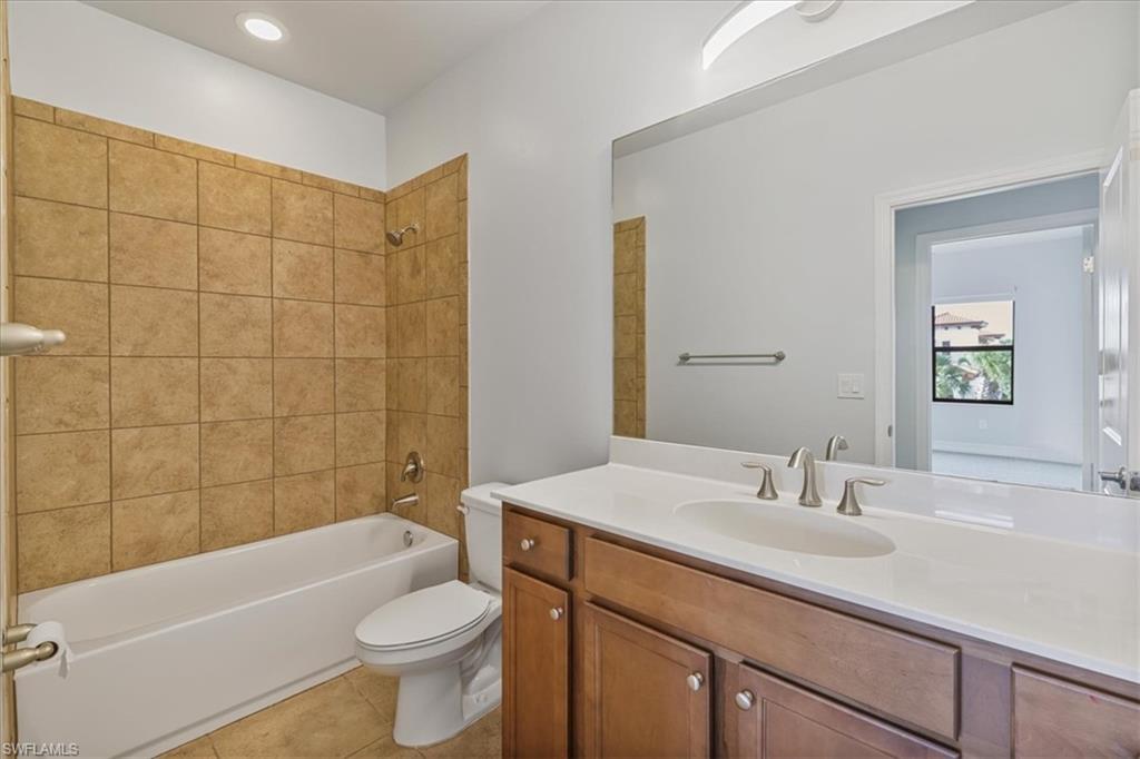 Full bathroom with vanity, toilet, washtub / shower combination, and tile patterned flooring