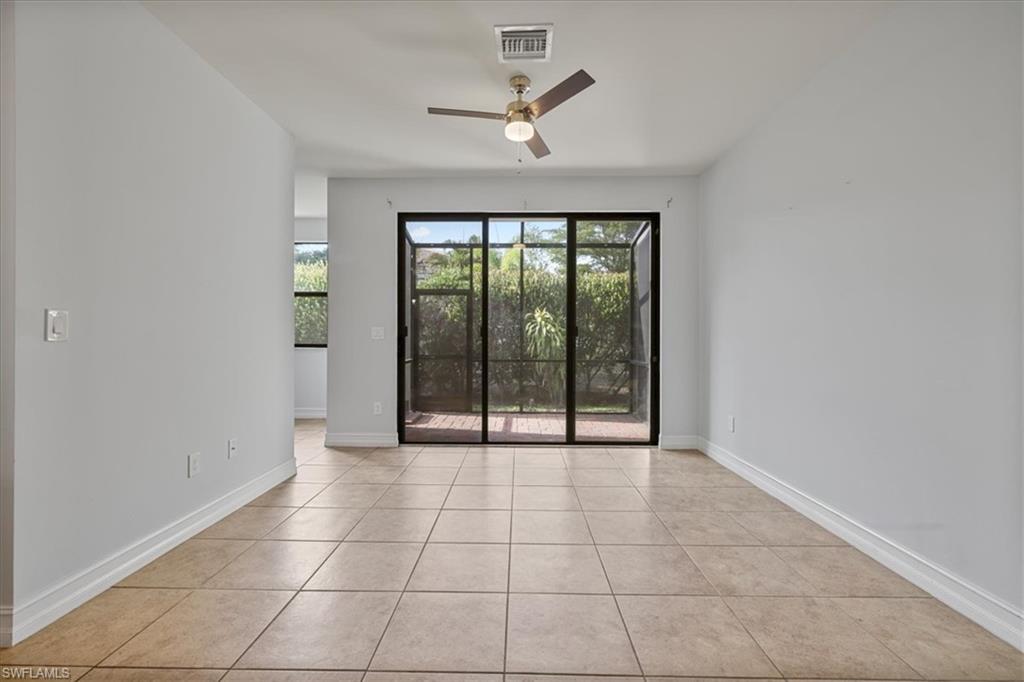 Unfurnished room featuring ceiling fan, light tile patterned flooring, and baseboards