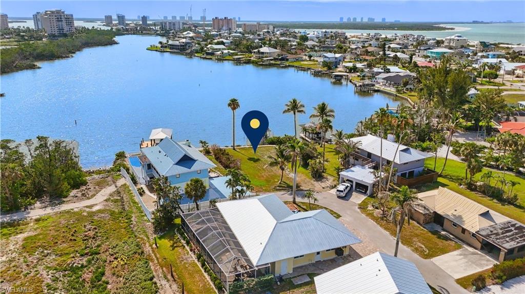 Aerial view of residential area with a nearby body of water and skyline  VIRTUALLY ENHANCED