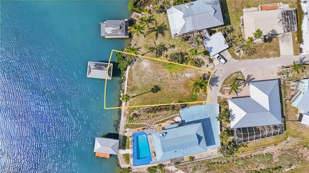 Drone / aerial view of a pool and a large body of water-  VIRTUALLY ENHANCED