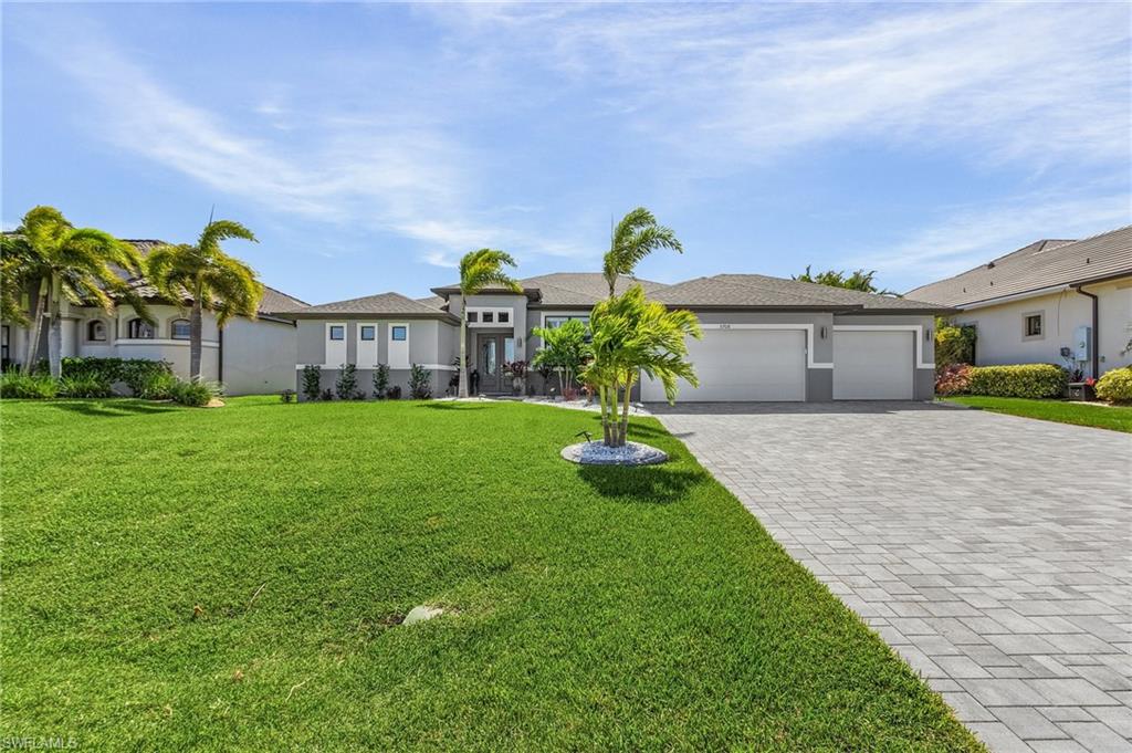 View of front of property featuring a garage and a front lawn