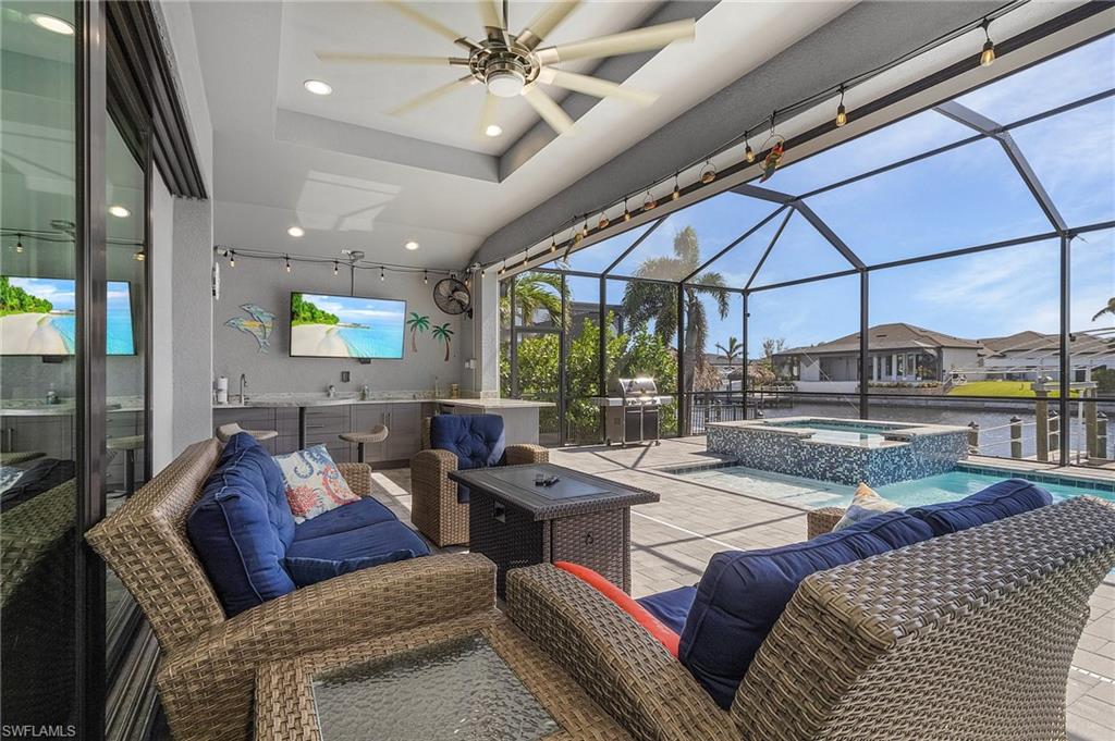 View of patio / terrace featuring ceiling fan, a pool with hot tub, and a lanai
