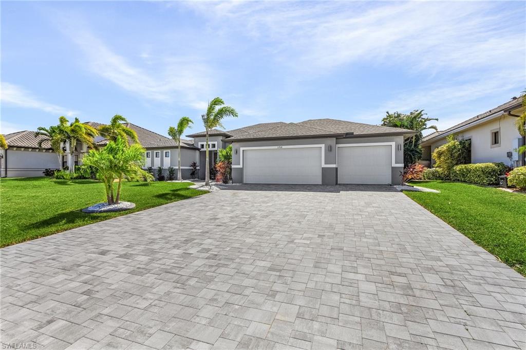 View of front facade featuring a front yard and a garage