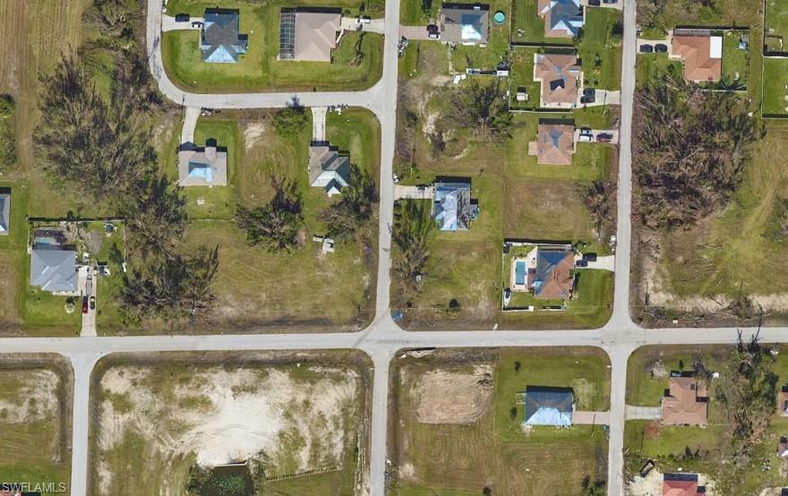 Aerial view of property and surrounding area with nearby suburban area