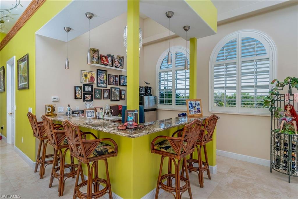 Indoor wet bar with ample seating for entertaining,  decorative light fixtures