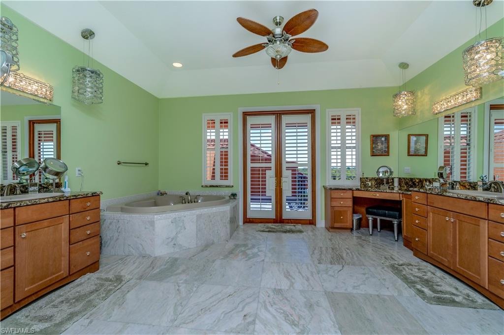 Master bathroom upstairs with double vanities, sinks, jetted tub, rain shower, specialty crystal lighting, Onxy flooring, ceiling fans and balcony