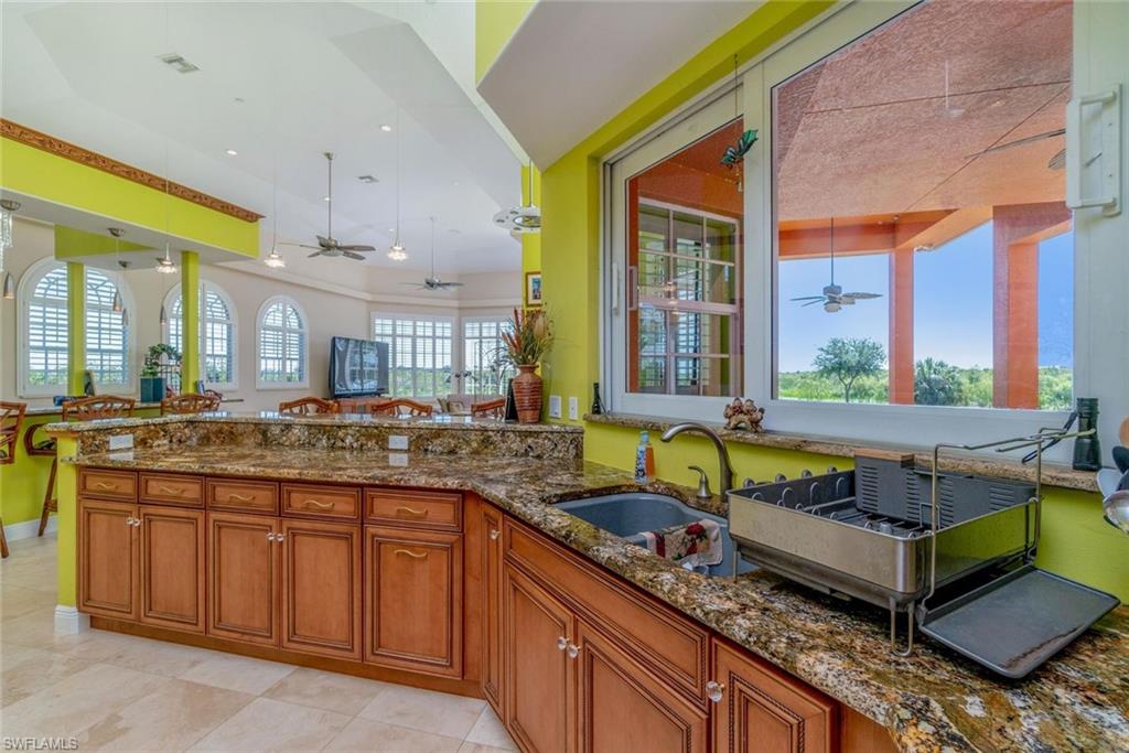Kitchen with appliances with stainless steel finishes, med brown Brookwood cabinetry, high counters, and granite countertops, high ceiling