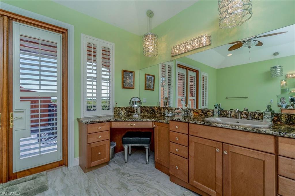 Master bathroom upstairs with double vanities, sinks, jetted tub, rain shower, specialty crystal lighting, Onxy flooring, ceiling fans and balcony