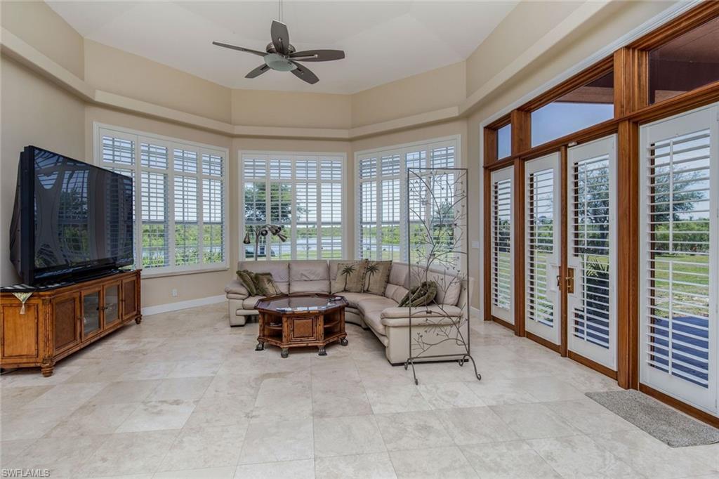 Living room with tray ceiling, indirect lighting, ceiling fans & panaramic water view
