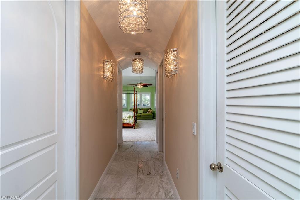 Corridor from Master bedroom to master bathroom, specialty chandeliers, and vaulted ceiling