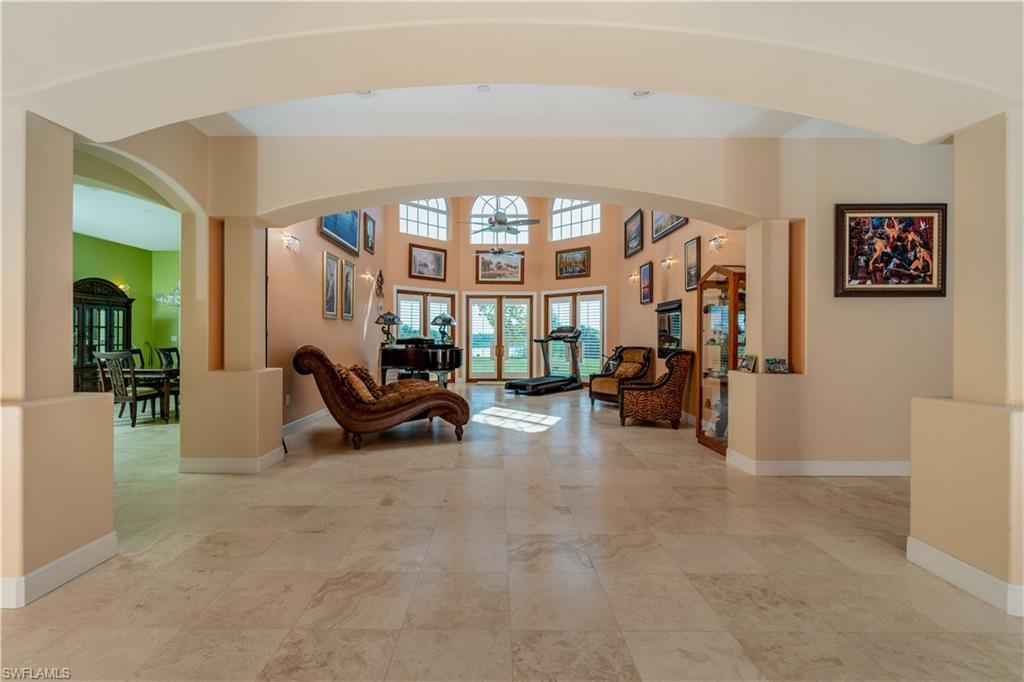 Great room featuring arched walkways, ceiling fans, fireplace, french doors and water view