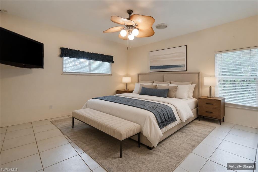 Unfurnished bedroom with light colored carpet, baseboards, and ceiling fan