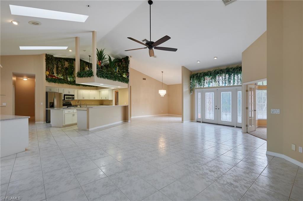 Unfurnished office with light carpet, ceiling fan, and baseboards
