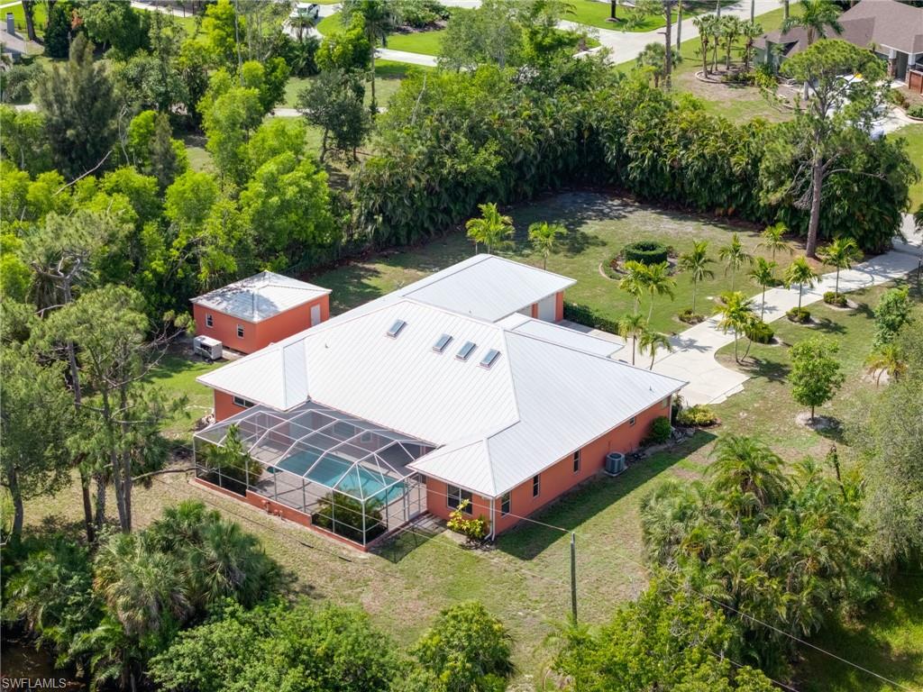 Aerial view of property and surrounding area with a tree filled landscape