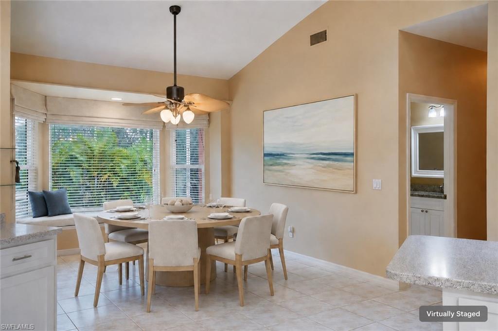 Dining room with a ceiling fan, light tile patterned flooring, baseboards, and lofted ceiling