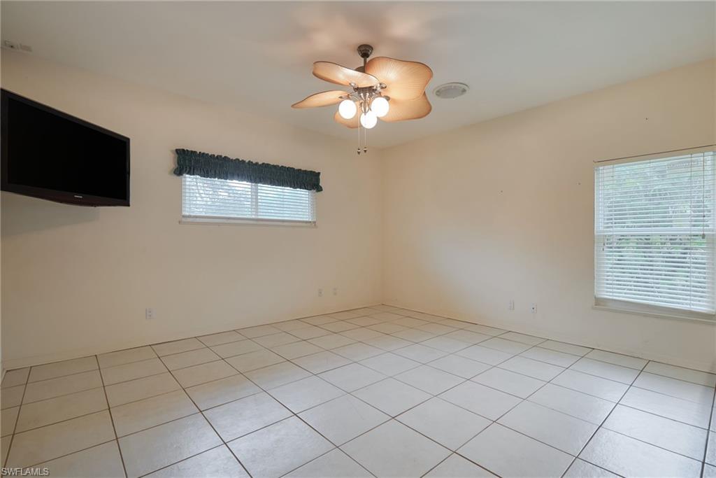 Laundry room featuring washing machine and dryer, cabinet space, light tile patterned flooring, and baseboards