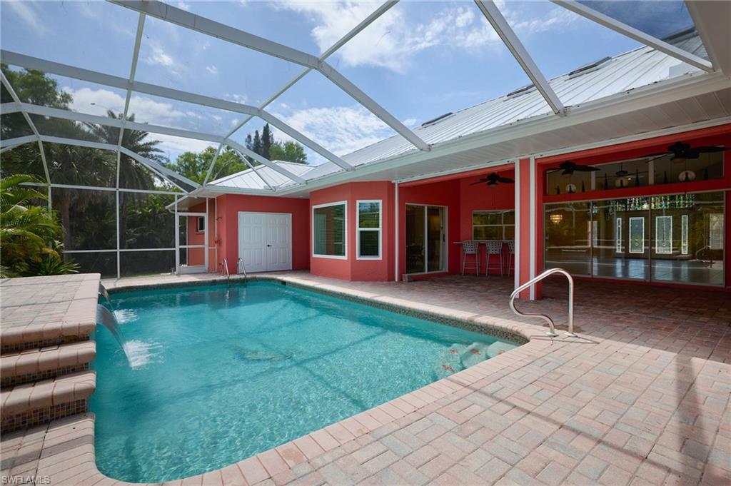 Back of property with central AC, a lawn, stucco siding, and a lanai