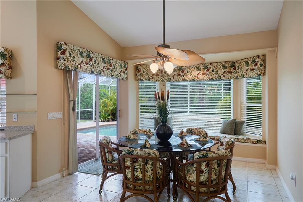 Spare room featuring high vaulted ceiling, light tile patterned flooring, a skylight, ceiling fan, and baseboards