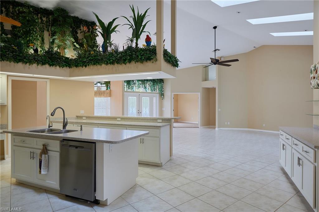 Dining area with ceiling fan, light tile patterned floors, vaulted ceiling, and baseboards