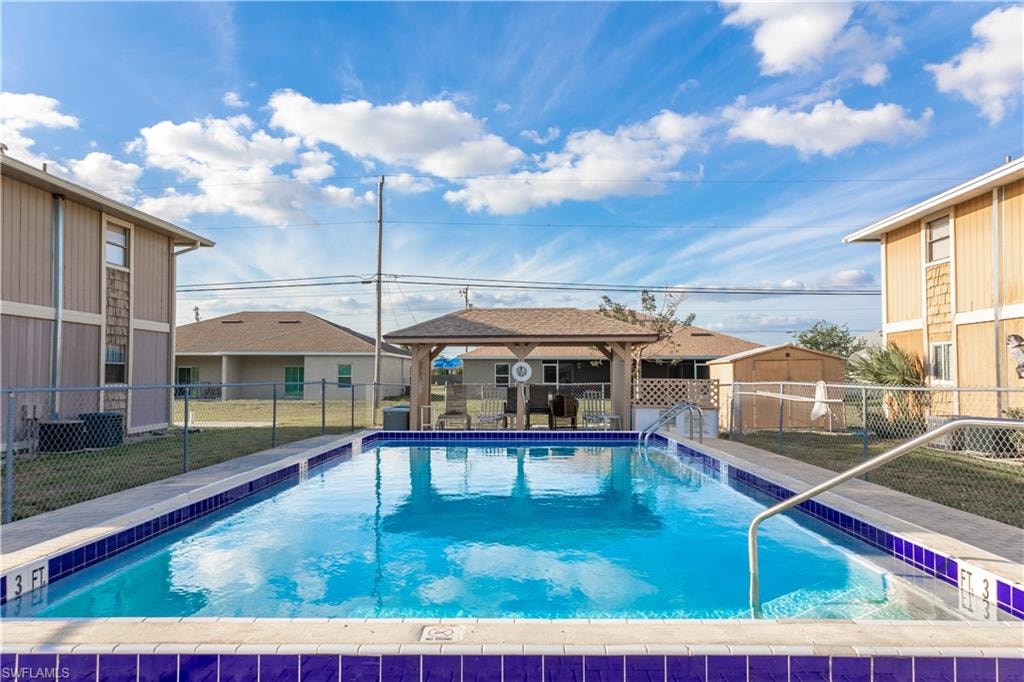 Community pool featuring a gazebo and a fenced backyard