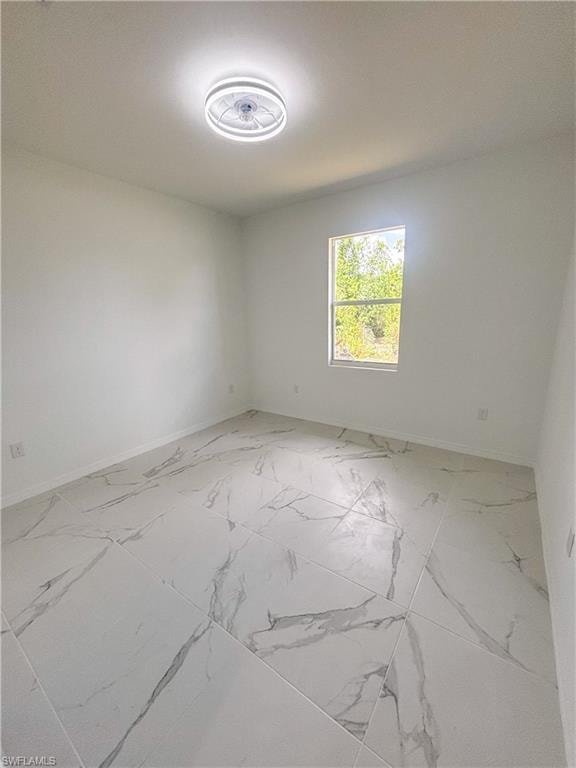 Unfurnished bedroom with light marble finish flooring and baseboards