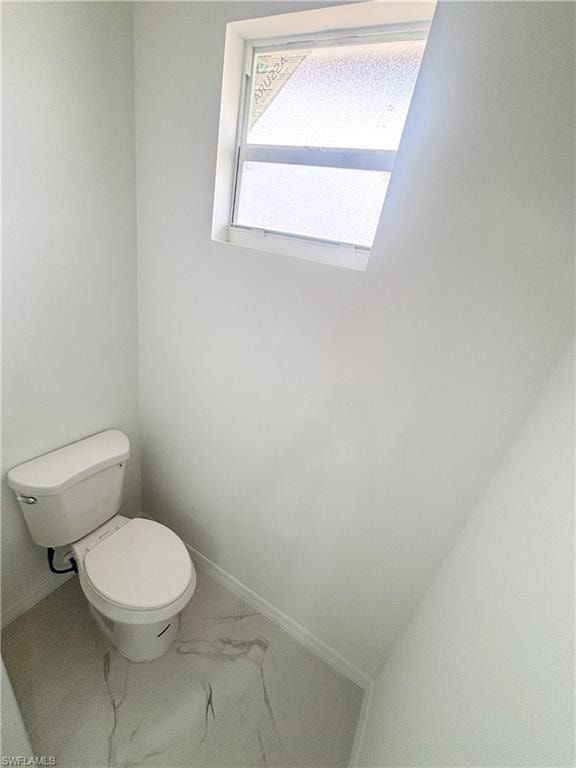 Empty room with a raised ceiling, light marble finish floors, and recessed lighting