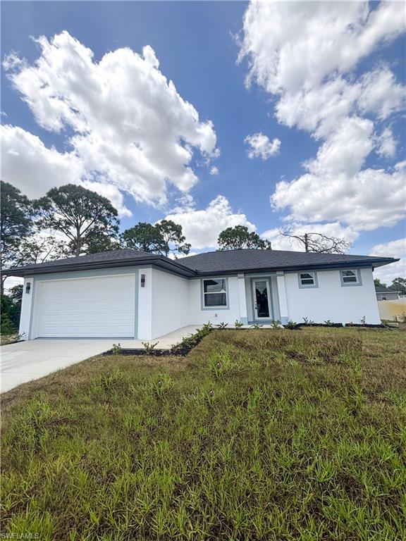 Ranch-style house with driveway, stucco siding, a garage, and roof with shingles