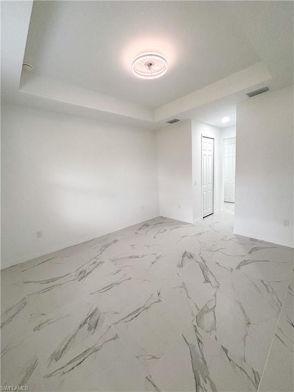 Bathroom featuring vanity, a marble finish shower, light marble finish floors, and recessed lighting
