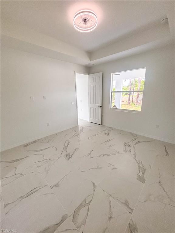 Unfurnished room with light marble finish floors and baseboards