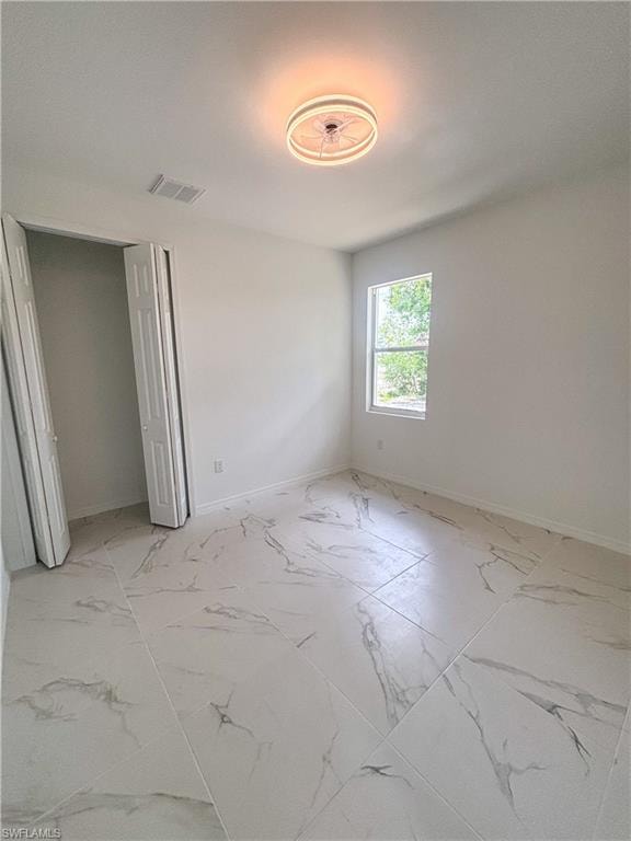 Full bath featuring vanity, combined bath / shower with glass door, and light marble finish flooring