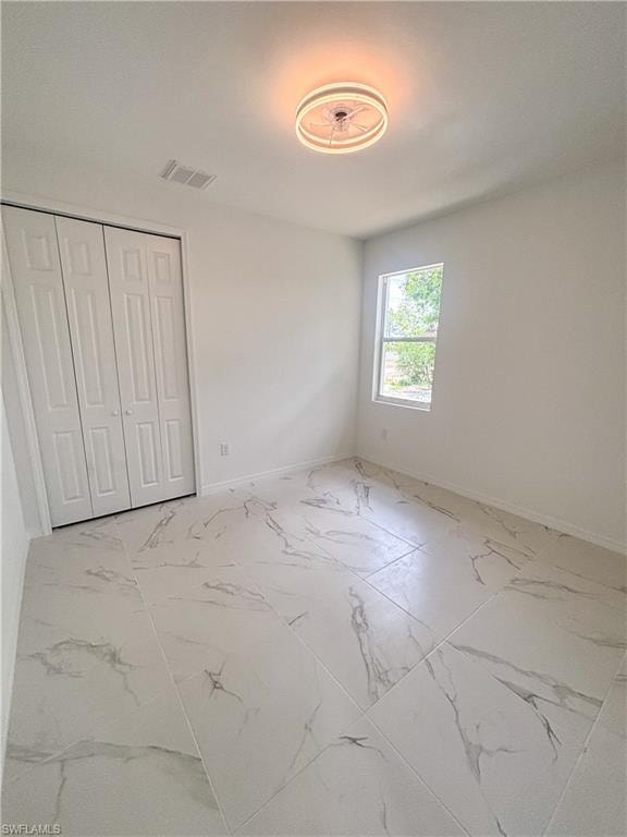 Kitchen with a raised ceiling, stainless steel appliances, white cabinets, light stone counters, and recessed lighting
