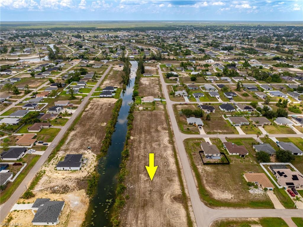 Aerial view of property's location with nearby suburban area and a nearby body of water